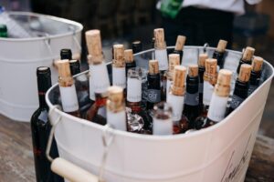 Bouteilles de vins Léoube et C&T, avec bouchons de liège, dans un seau à glace blanc rempli de glaçons, prêtes à être servies.